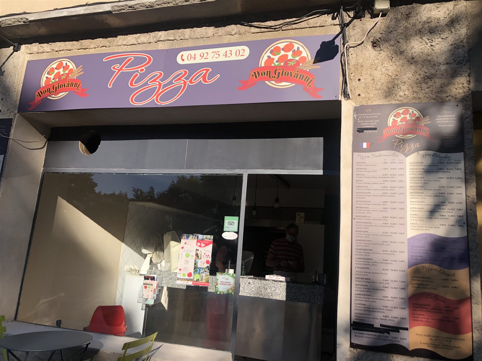 La façade de jour : enseigne « Pizza » avec le numéro de téléphone et la carte affichée à droite