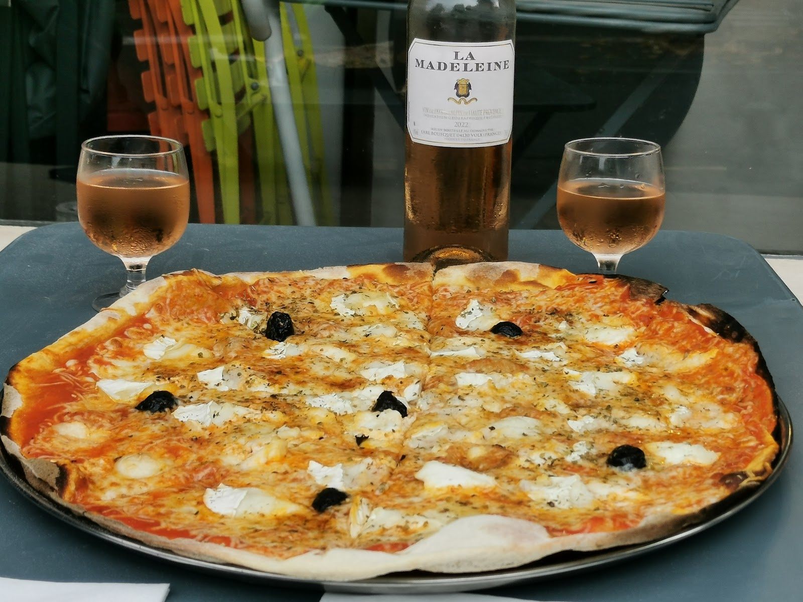 Pizza au chèvre et aux olives avec deux verres de rosé de Haute-Provence